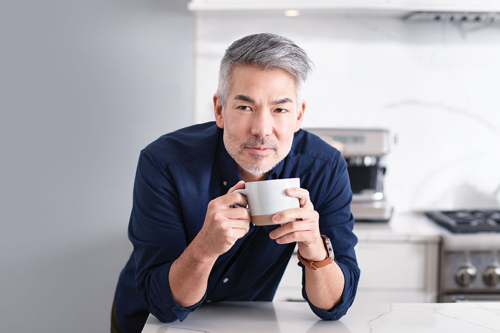 man in kitchen with cup of espresso